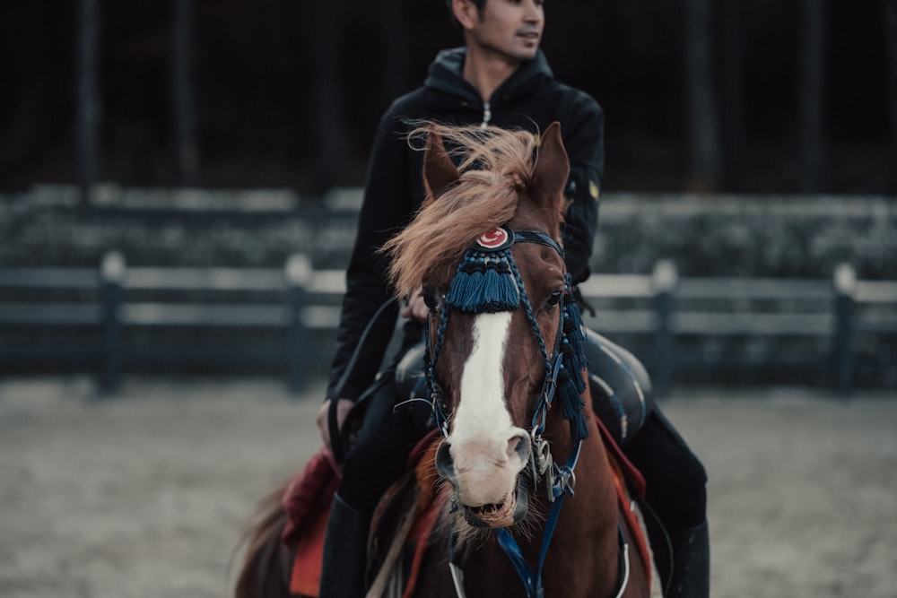 a man riding on the back of a brown and white horse