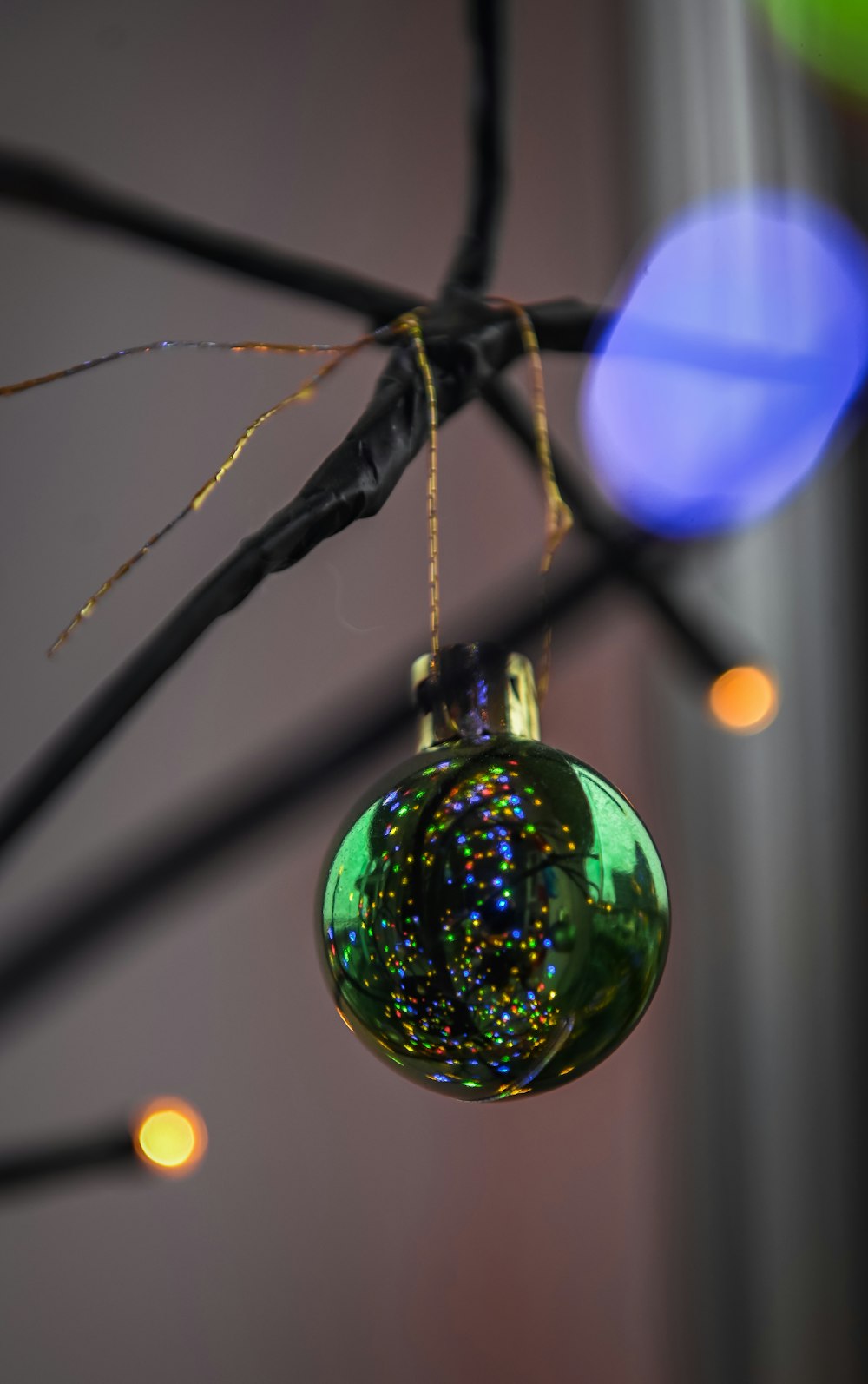 a green ornament hanging from a tree