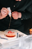 A slow-motion pour of sauce being drizzled over a plated dish.