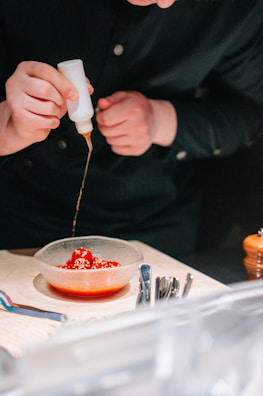 A slow-motion pour of sauce being drizzled over a plated dish.