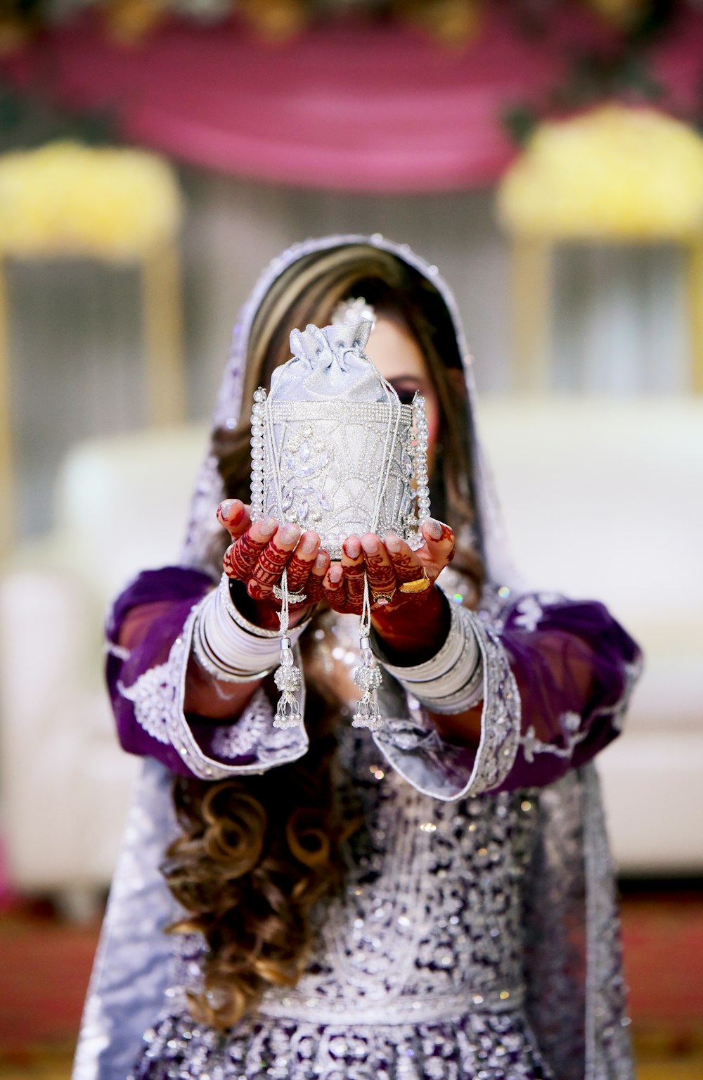 a woman in a purple dress holding a cake