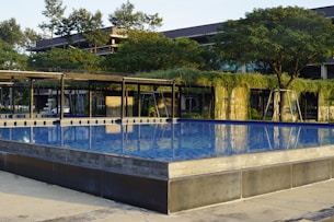 A modern pool with clean lines, surrounded by tropical plants and accented with sky-blue tiles and warm wood finishes.