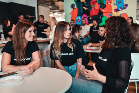 A group of diverse individuals sharing smiles and engaging in a supportive discussion.