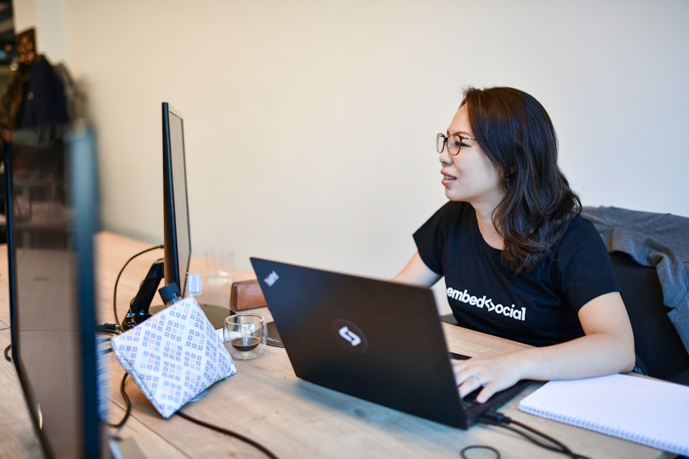 a woman sitting at a table with a laptop