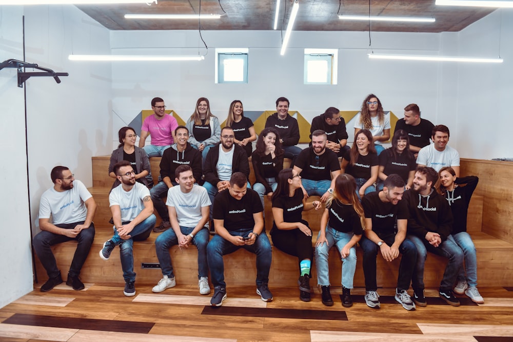 a group of people sitting on top of a wooden bench