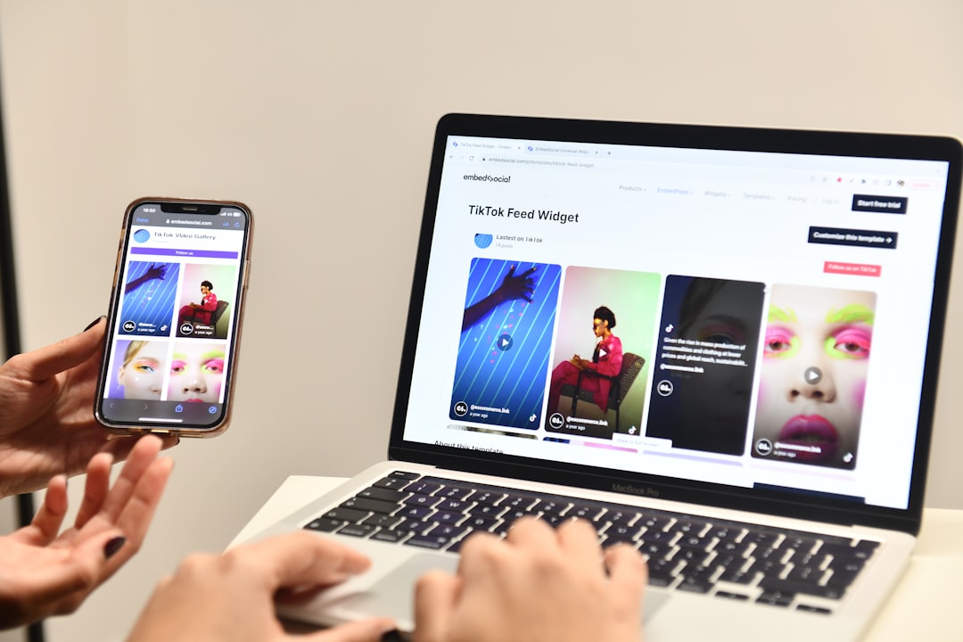 a person holding a cell phone next to a laptop, Display user-generated content with the Instagram widget on your website with EmbedSocial.