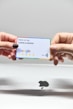 two hands holding a google credit card in front of an apple logo