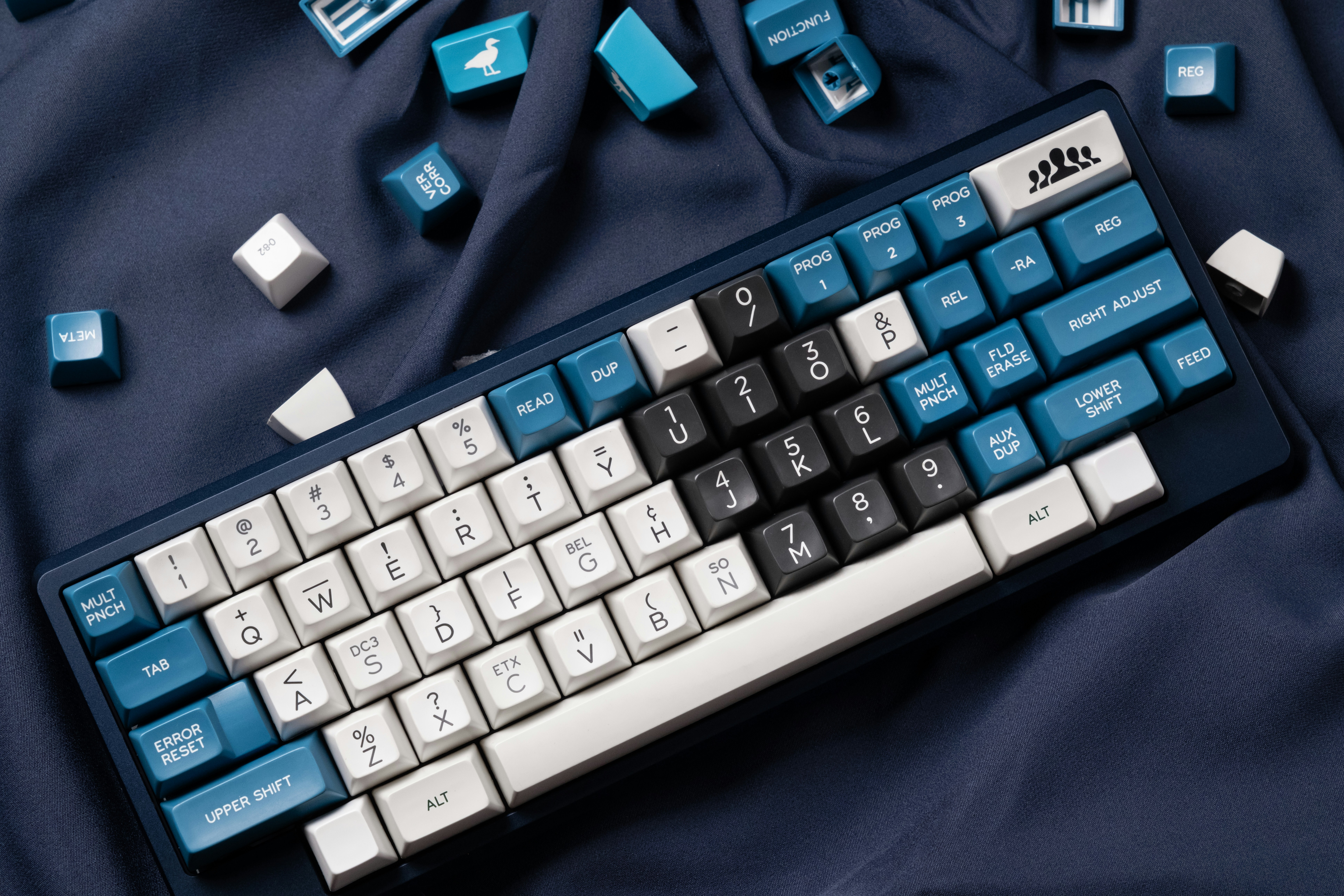 a computer keyboard sitting on top of a blue blanket