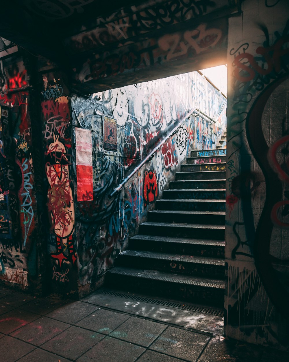 a stairwell with graffiti on the walls and steps