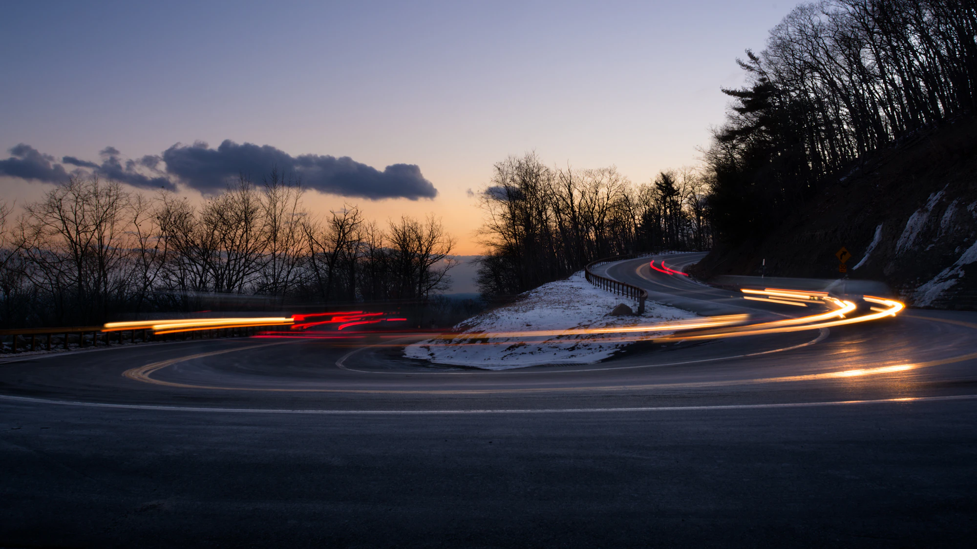 Mountain hairpin drawn by headlights at night