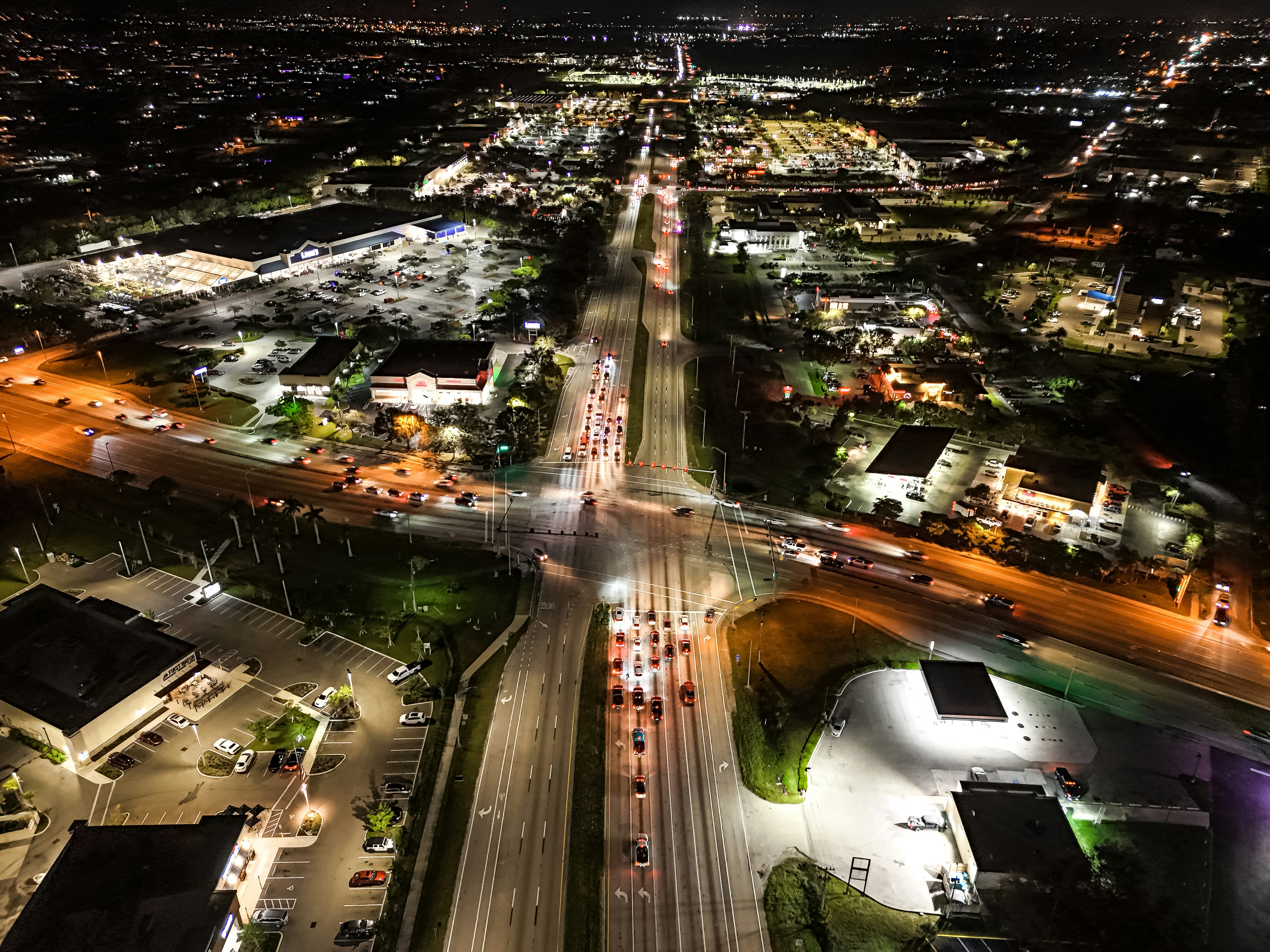 Busy highway interchange with multiple lanes of traffic at night