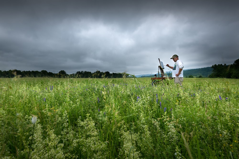 a man standing in a field with a bike