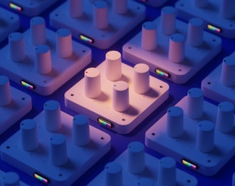 Several white square platforms are arranged in a grid pattern, each with three cylindrical knobs on top. The platforms have a small colorful display on the side, and they are illuminated by a soft purple and orange light, casting gentle shadows.