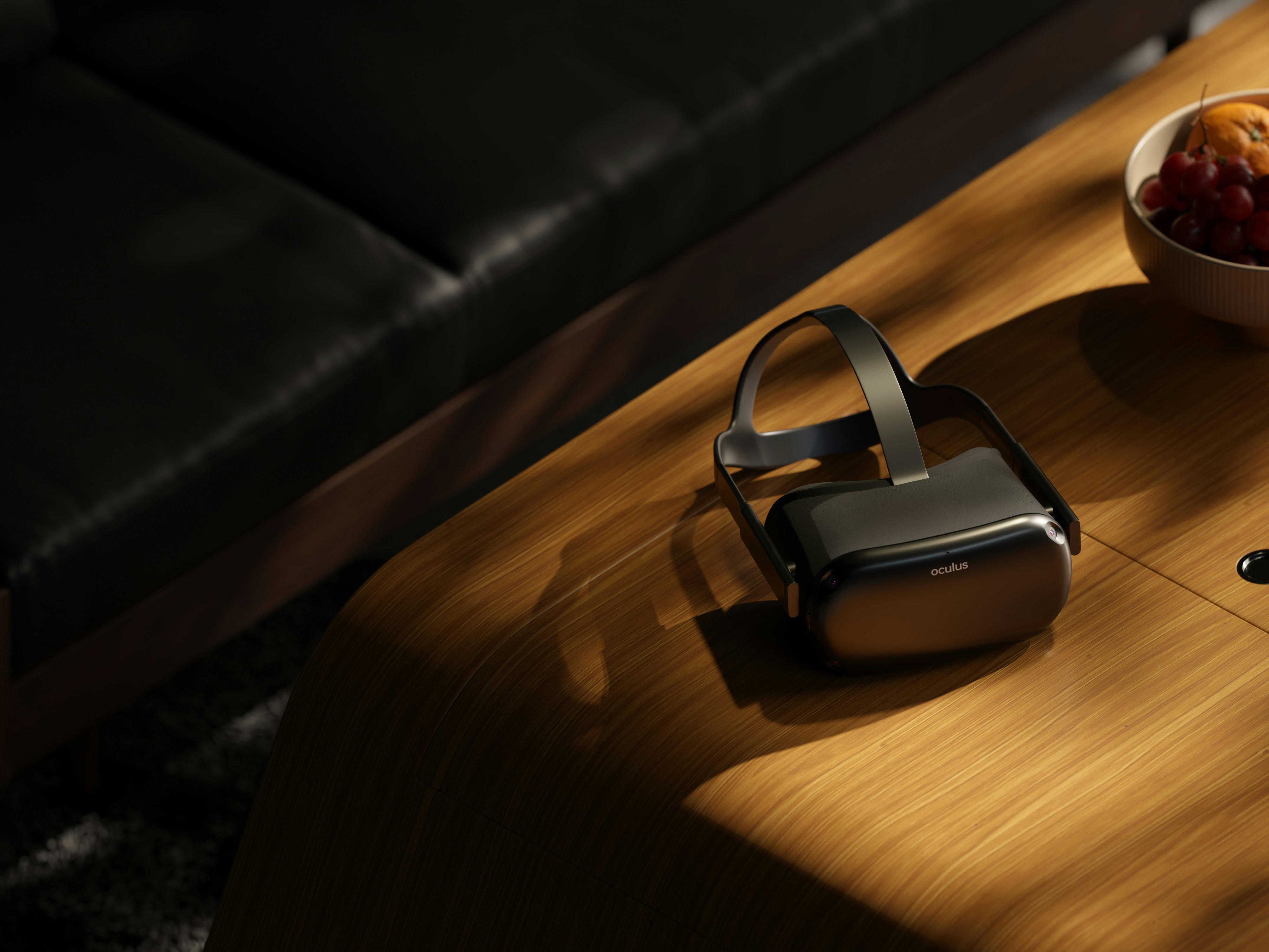 a table with a bowl of fruit and a pair of headphones on it