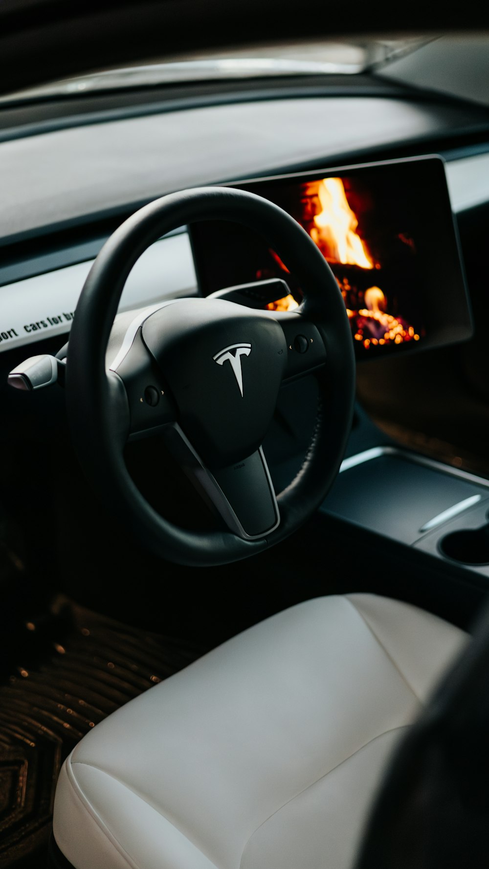 the interior of a car with a fire in the background