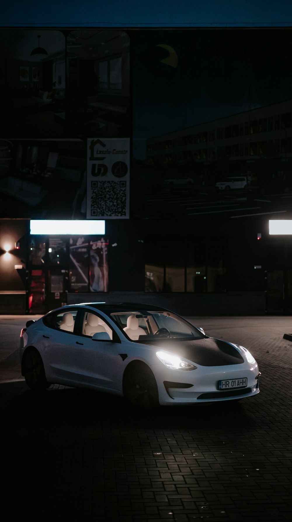 a white car parked in a parking lot at night