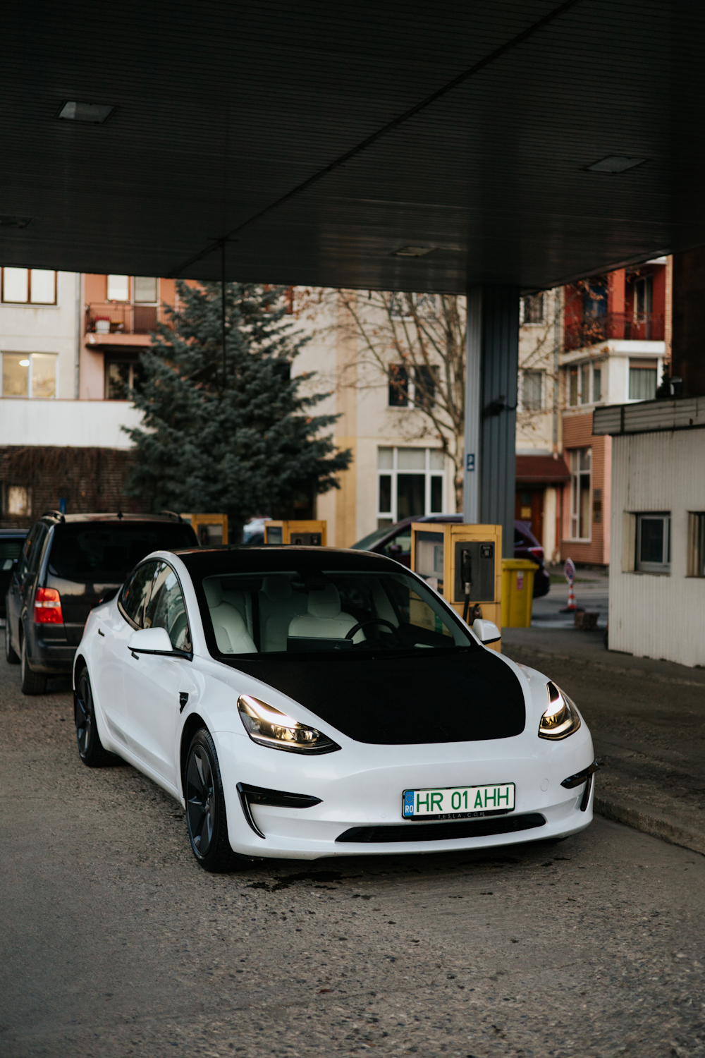 a white and black car parked under a bridge