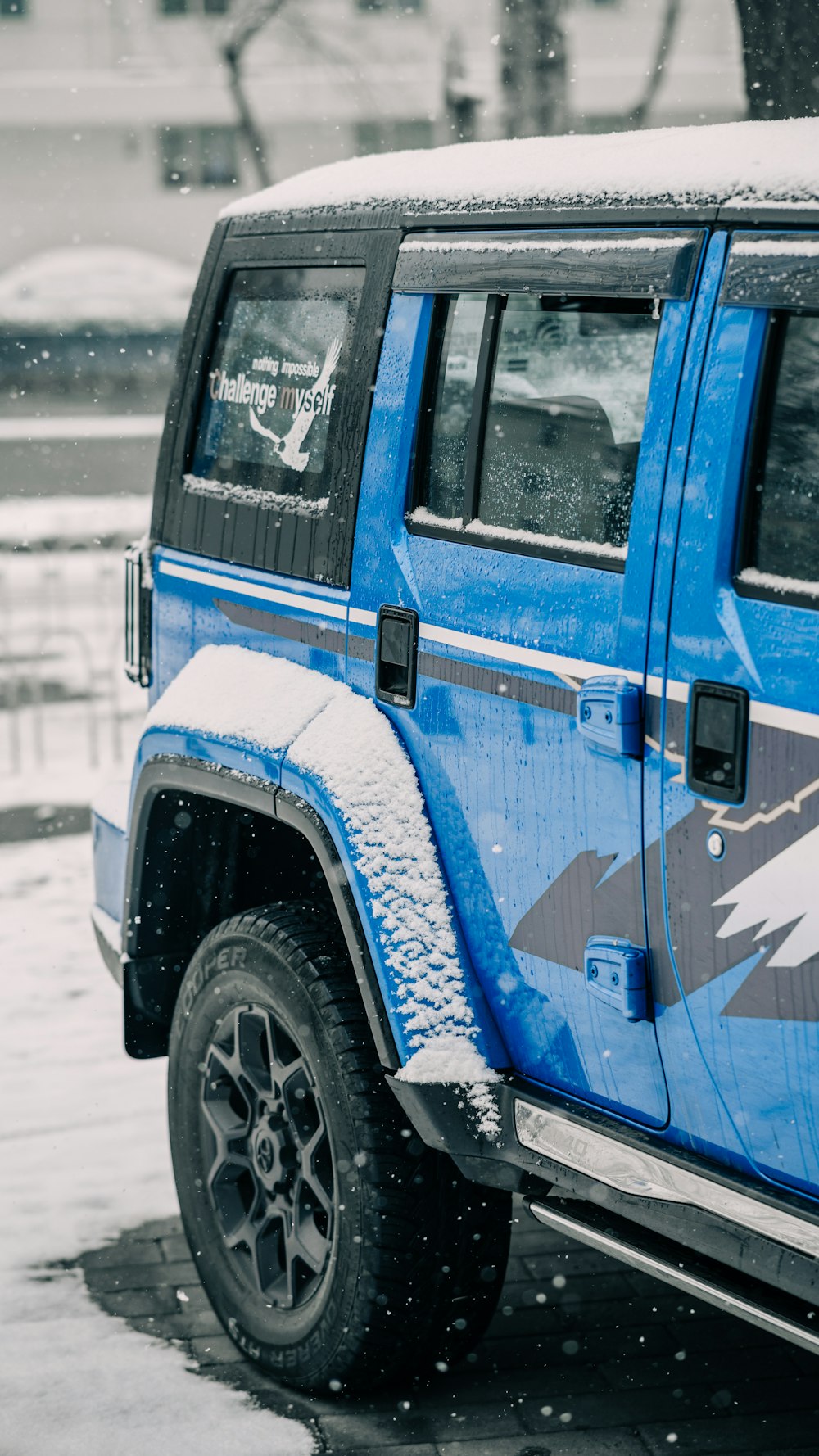 a blue jeep is parked in the snow