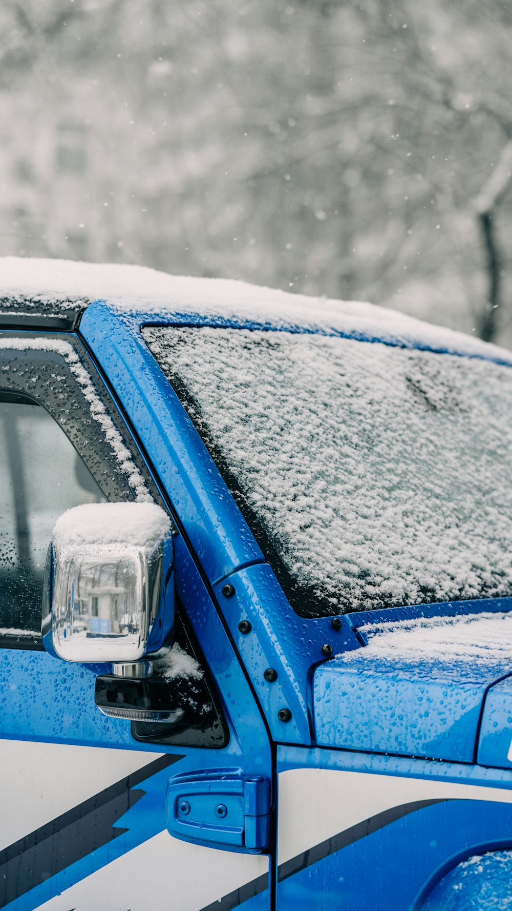 a blue and white truck covered in snow