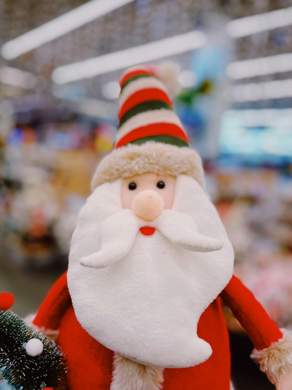 a santa clause doll with a christmas tree in the background