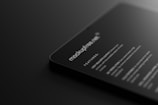 A dark-themed digital mockup showcasing a sleek, rounded-corner device featuring text that includes features and specifications. The text is white against a black background, giving a modern and minimalistic feel.