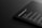 A dark-themed digital mockup showcasing a sleek, rounded-corner device featuring text that includes features and specifications. The text is white against a black background, giving a modern and minimalistic feel.