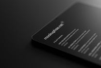 A dark-themed digital mockup showcasing a sleek, rounded-corner device featuring text that includes features and specifications. The text is white against a black background, giving a modern and minimalistic feel.