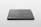 A sleek, rectangular black object with rounded corners rests on a light surface. Text in white is visible on its surface, listing features and specifications, suggesting it is a product mockup or digital screen template.