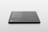 A sleek, rectangular black object with rounded corners rests on a light surface. Text in white is visible on its surface, listing features and specifications, suggesting it is a product mockup or digital screen template.