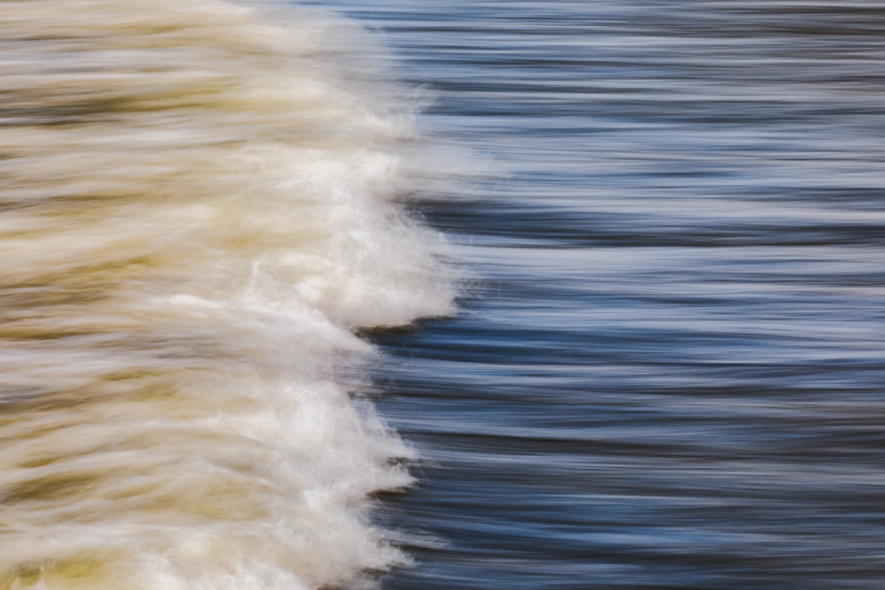 a blurry photo of a wave coming in to shore