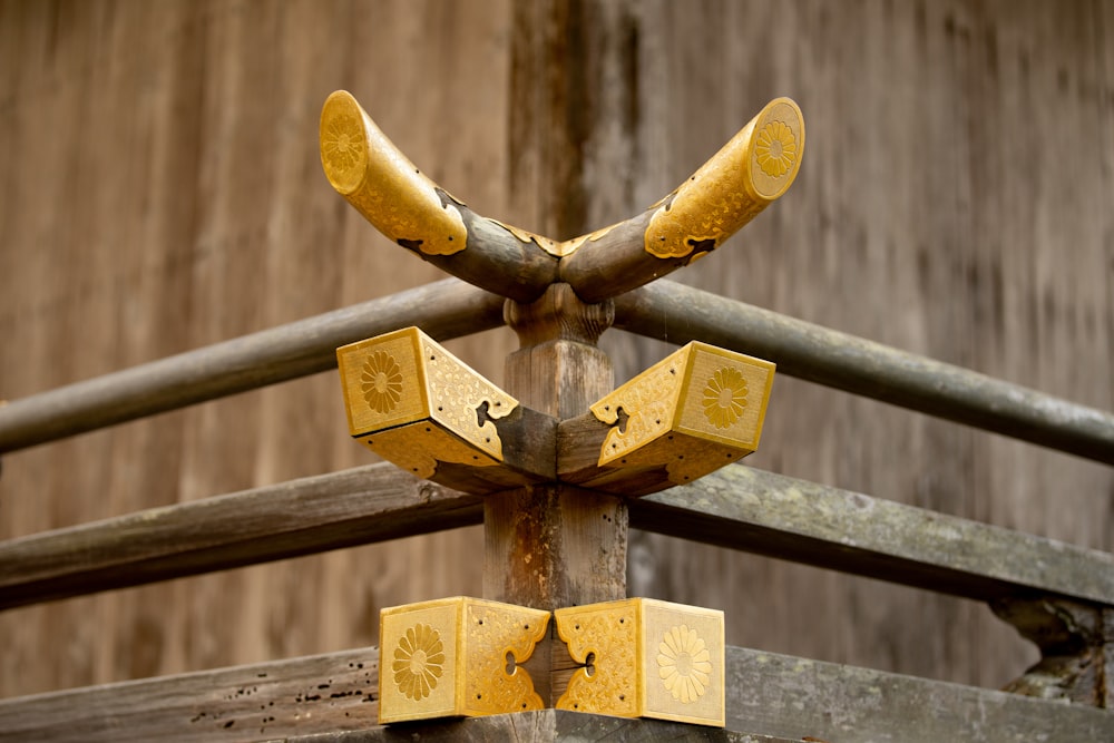 a close up of a metal fence with a wooden building in the background