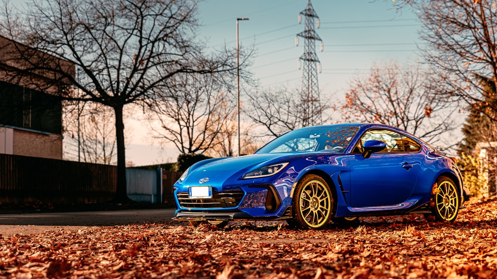 a blue sports car parked on the side of the road