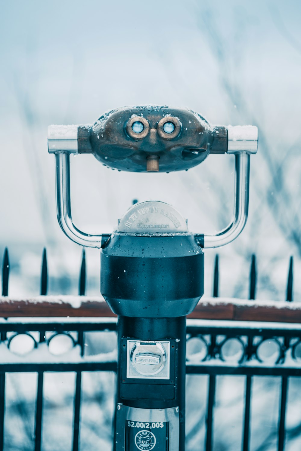 a parking meter sitting next to a fence