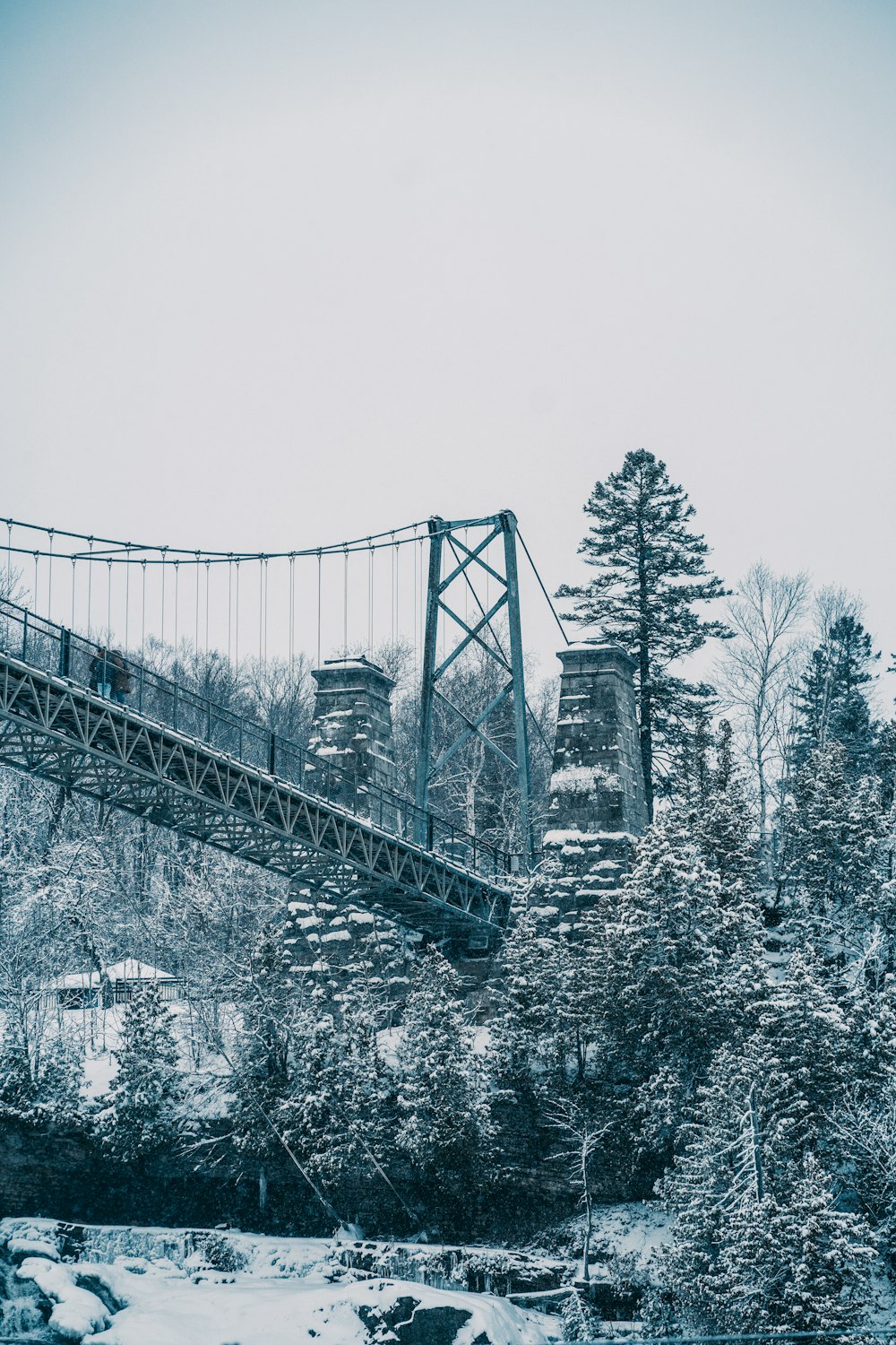 a bridge that is over a river in the snow