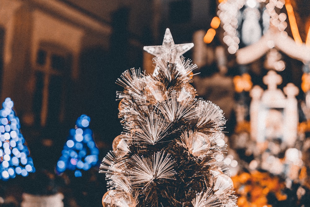 a close up of a christmas tree with lights in the background