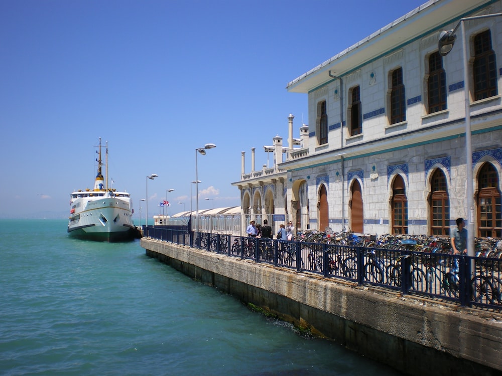 a large white boat in the water next to a pier