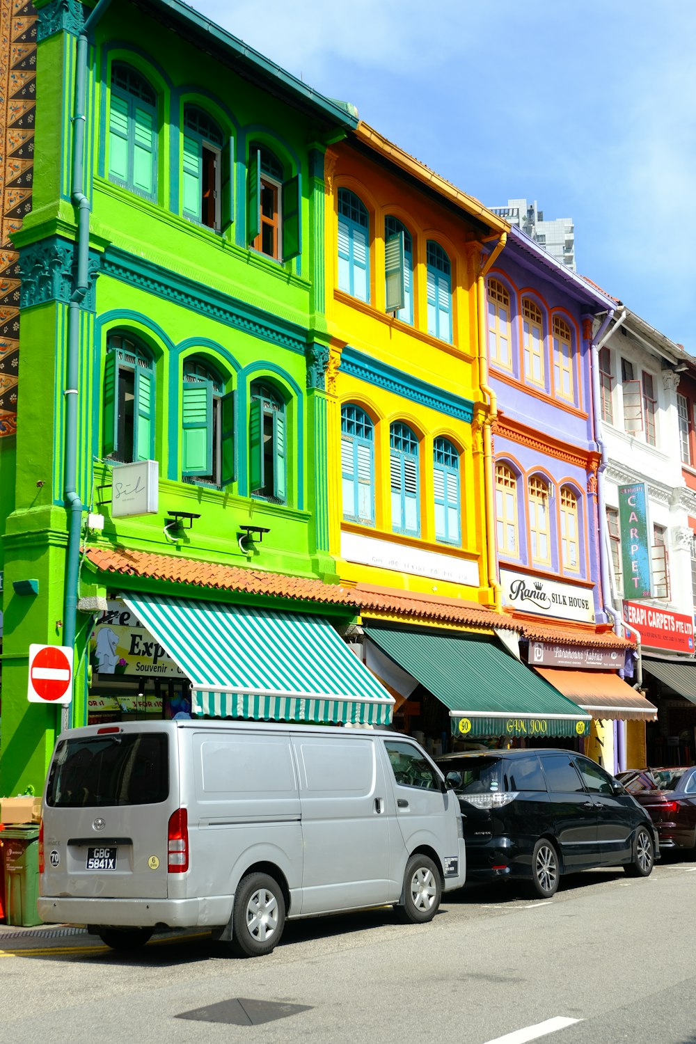 a row of multi - colored buildings on a city street