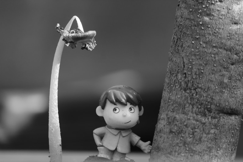 a small figurine is next to a tree