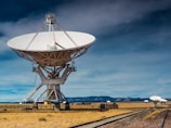 a very large satellite dish sitting on top of a train track