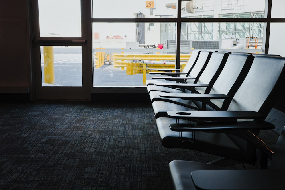 a row of black and white chairs sitting in front of a window