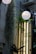 A vertical garden scene with hanging moss and white paper lanterns illuminating the area. There is a metal or glass surface with text, including phrases such as 'Film Never Die' and 'Think Positive, Shoot Negative'. The surroundings are urban, with elements like an air conditioning unit visible.