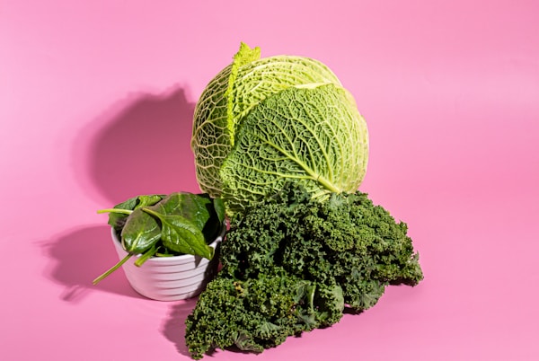 A head of cabbage next to a bowl of broccoli