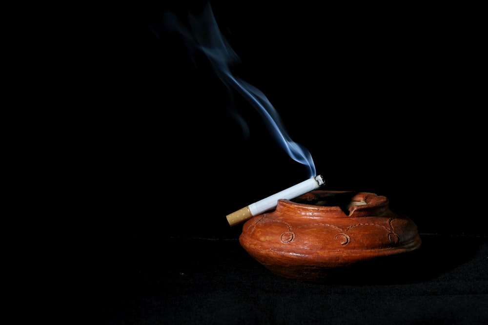 a lit matchstick sticking out of a wooden pot