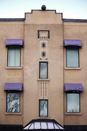 a tall building with purple awnings and windows