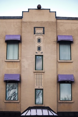 a tall building with purple awnings and windows