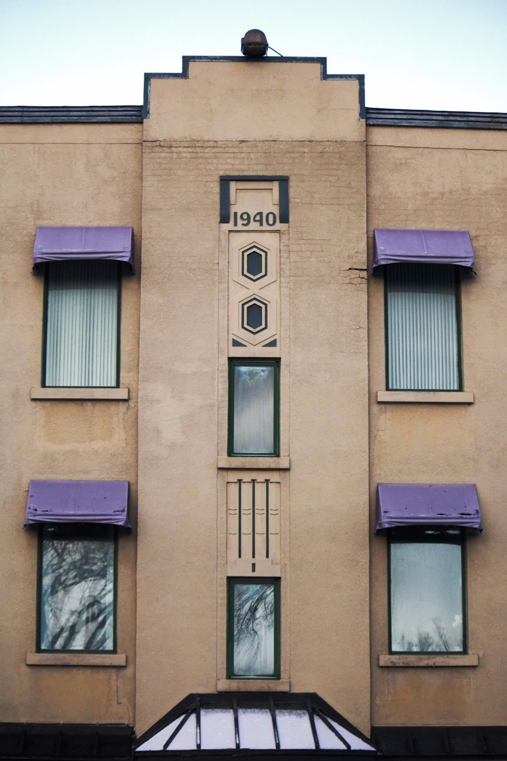 un edificio alto con tende da sole e finestre viola