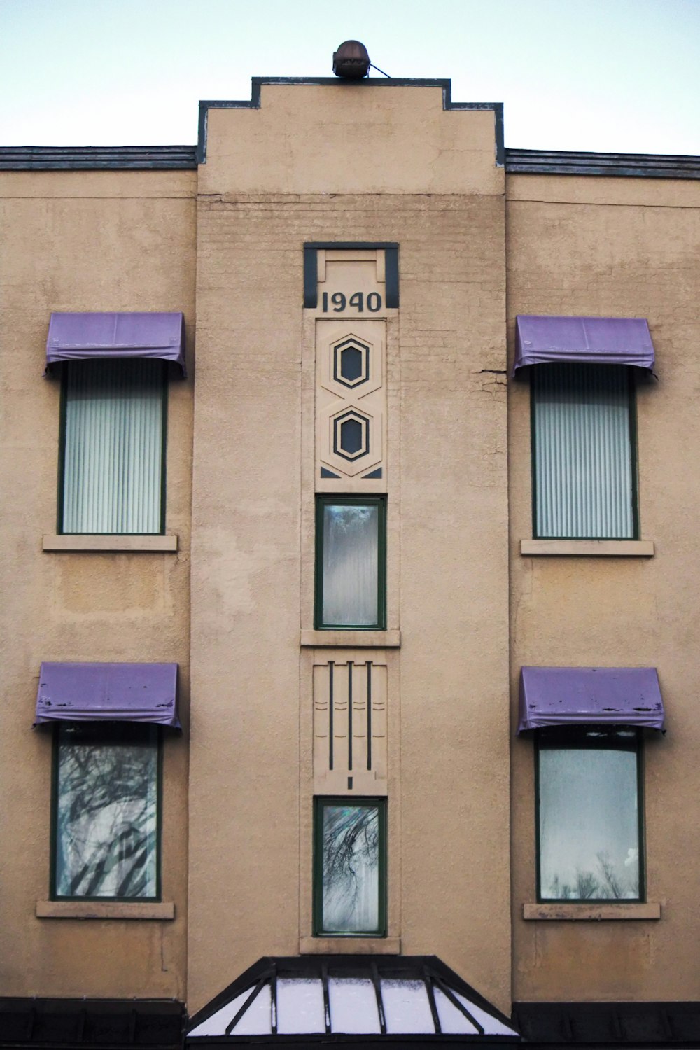 un grand bâtiment avec des auvents et des fenêtres violets