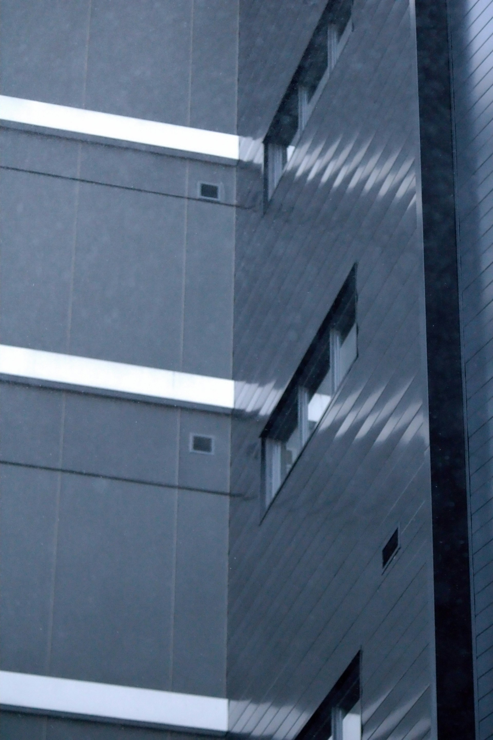 A commercial building facade featuring sustainable materials and integrated electrical and sanitary installations, reflecting a fresh architectural approach.