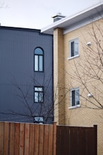 a tall brick building next to a wooden fence