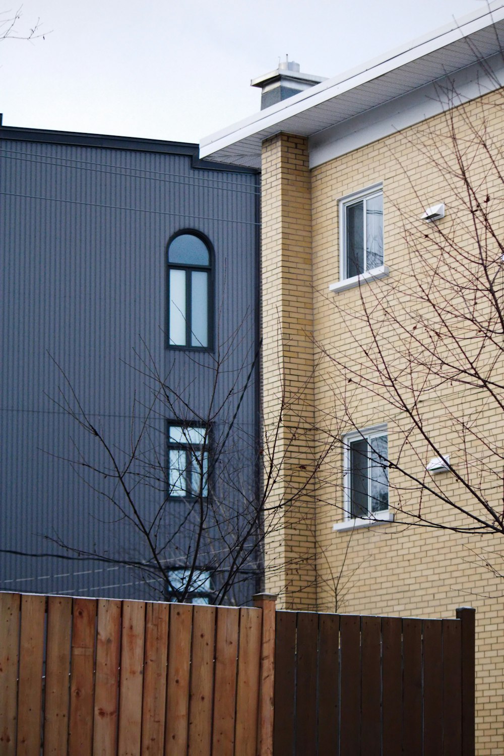 a tall brick building next to a wooden fence